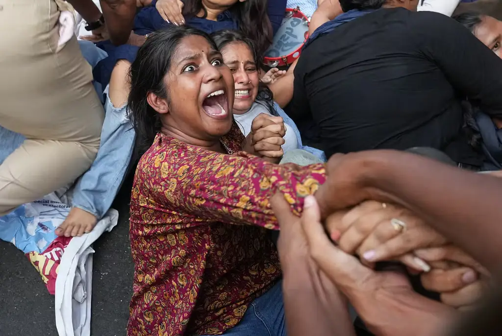 En kvinna grips under helgens protester i New Delhi.