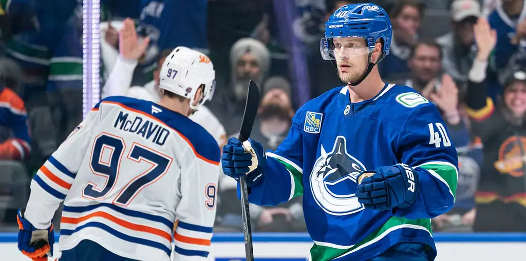 Elias Pettersson jublar efter sitt mål mot Edmonton Oilers. I bakgrunden syns storstjärnan Connor McDavid.