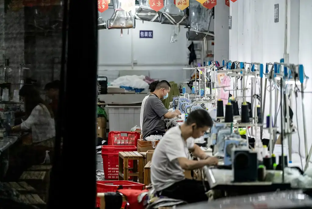 Workers in a garment-making district in Guangzhou. A weak renminbi is driving up costs of living for consumers while large rebates to exporters further drain national and local government finances hit by the housing slump.