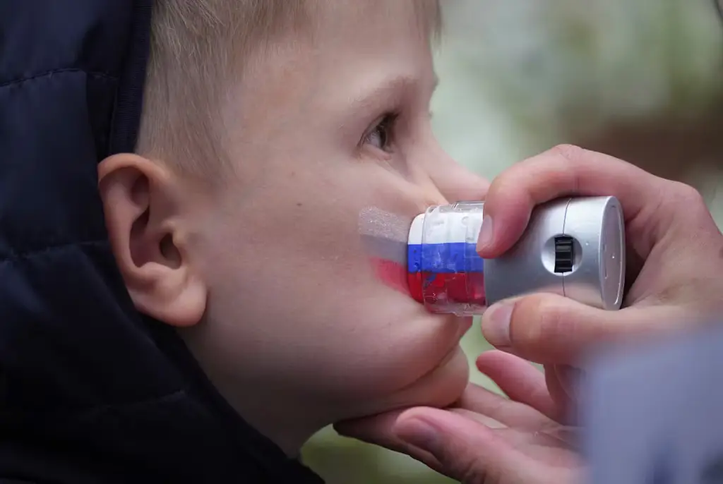 Ryska flaggan ansiktsmålas på en pojke inför ett firande i St Petersburg, 2025.