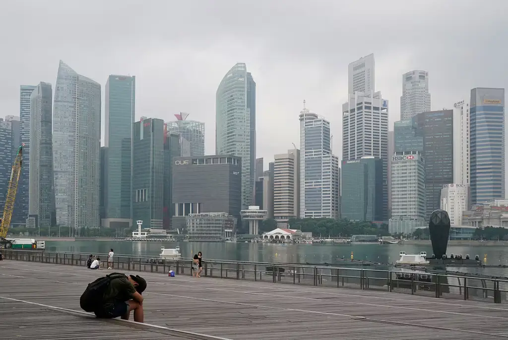 Ensam man med Singapores stadsbild i bakgrunden.